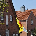Ein Teilnehmer des Greenpeace Energy Bayern Express zeigt Flagge auf dem Weg durch einen malerischen Strassenzug in Elmshorn.